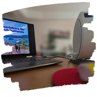 Laptop mit der Pr&auml;sentation eines Theoriekurses, daneben ein Lautsprecher